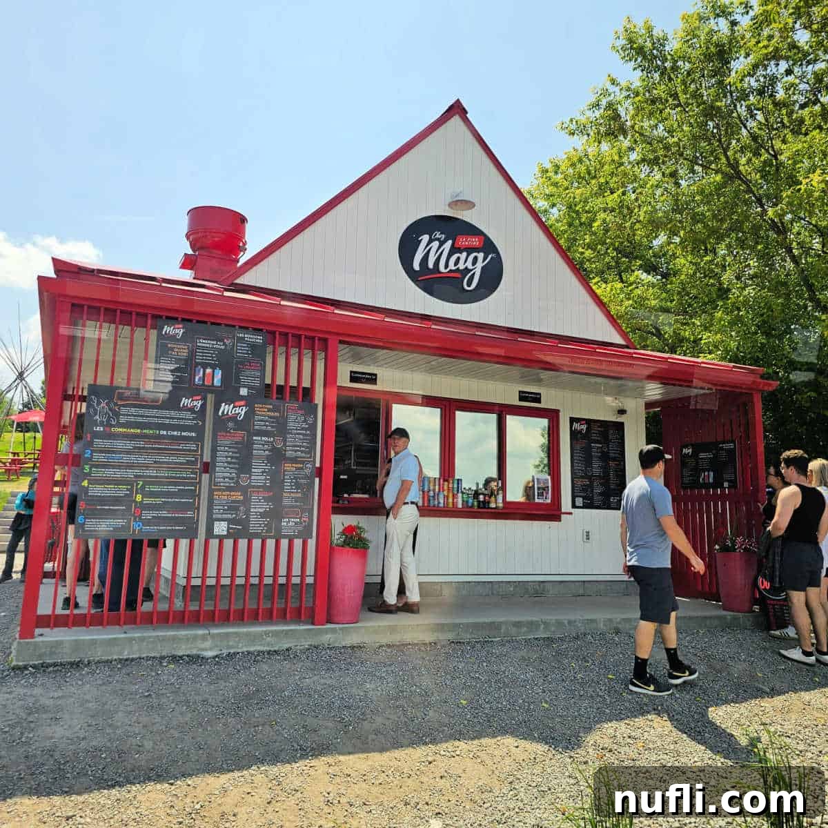The bustling Chez Mag red and white food stand, with a lively queue of people waiting to order