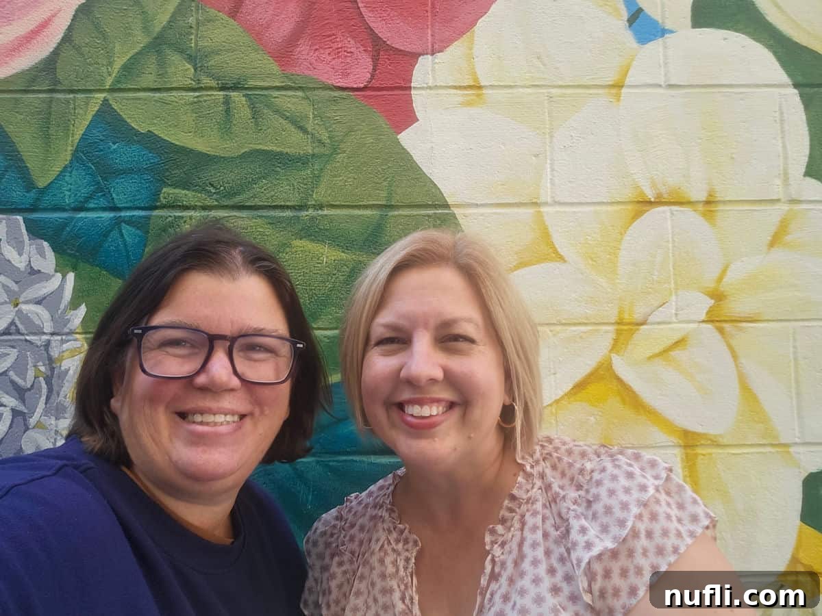 Tammilee and Kim in front of a floral mural