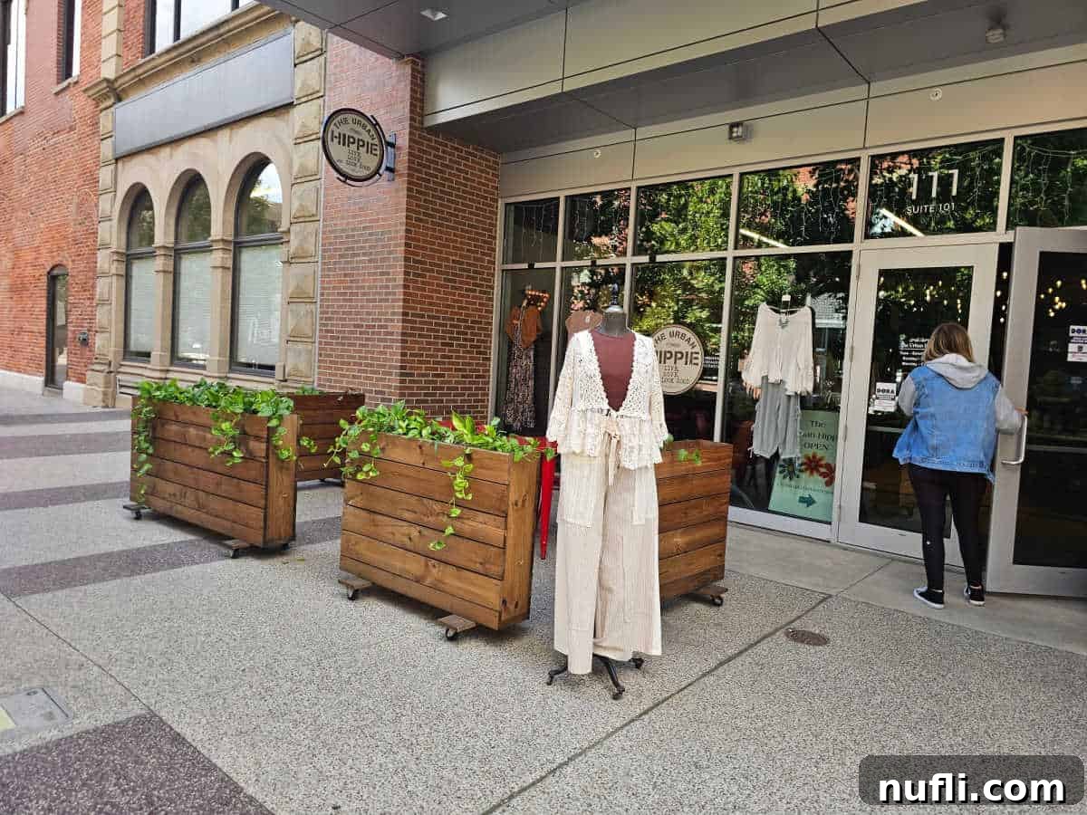 The Urban Hippie circle sign on the window with manequin outside of the store and person walking into the store