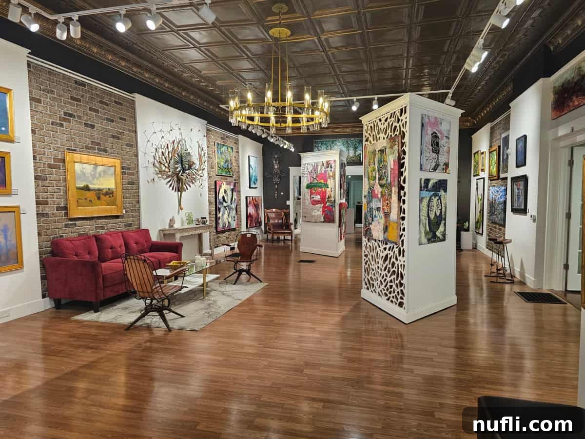 O2 Gallery with art on the wall, red couch and chairs,