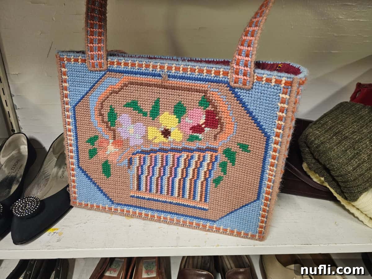 needlepoint bag next to black shoes and a sweater on a shelf