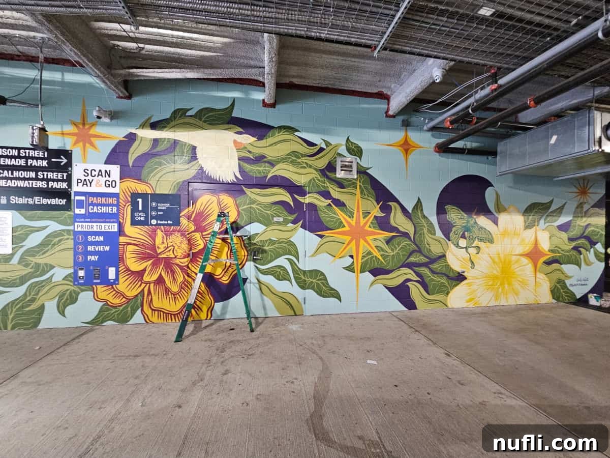 mural in progress with a bird and flowers, ladder in front of the mural
