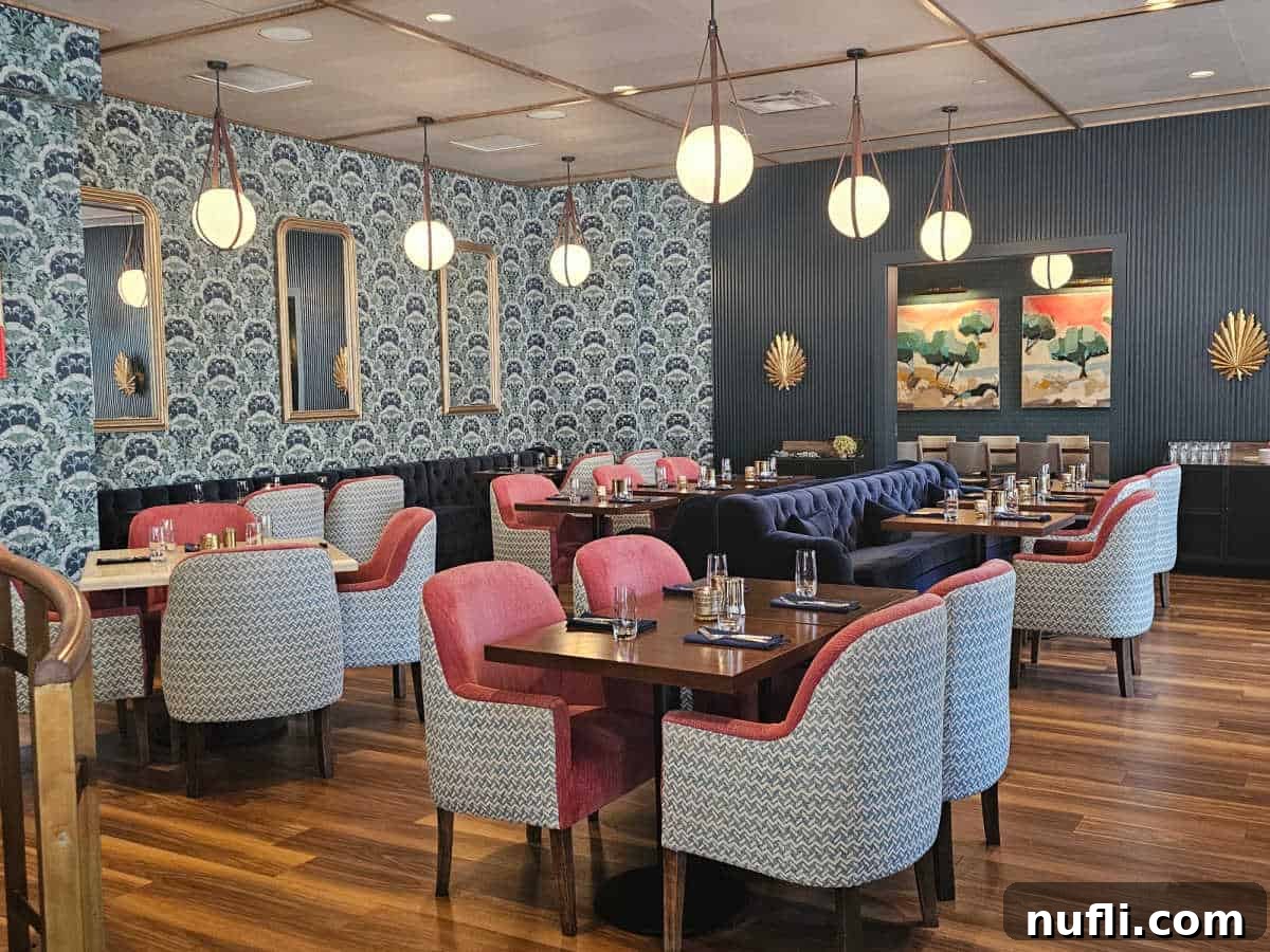 Arbor restaurant with pink and blue chairs, long blue velvet couch, blue wall paper and hanging ball lights
