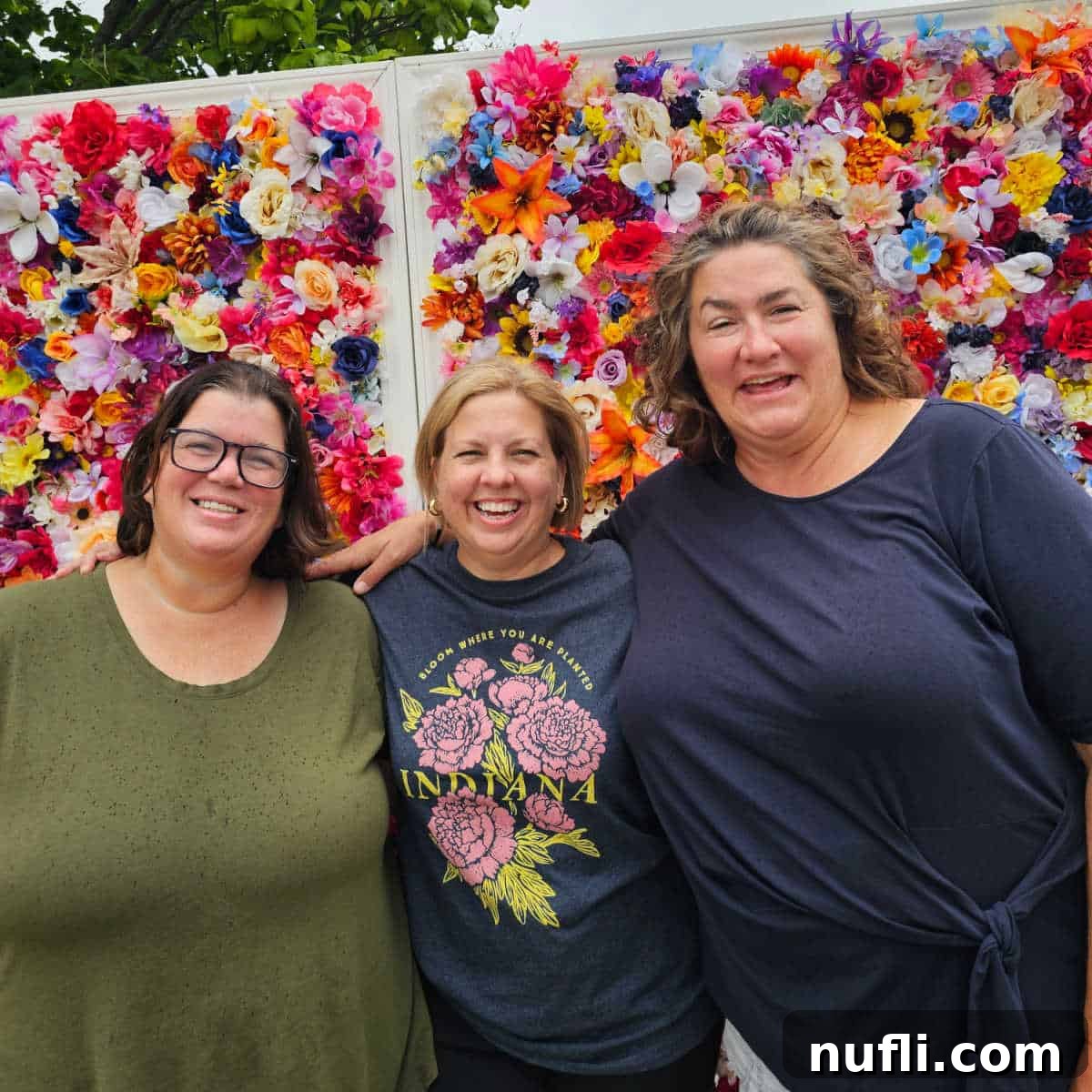Tammilee, Kim, and kristen in front of a flower wall