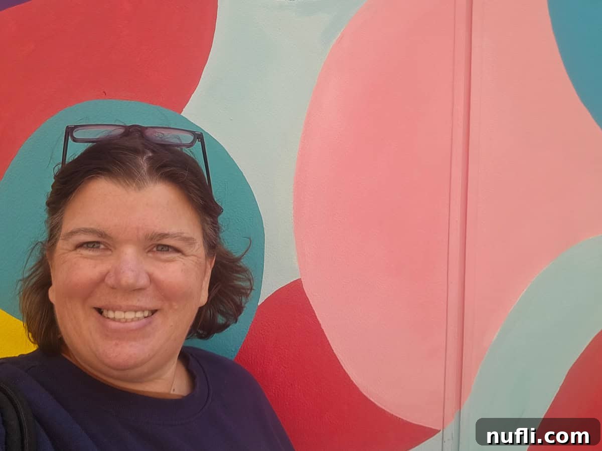 Tammilee next to a colorful mural