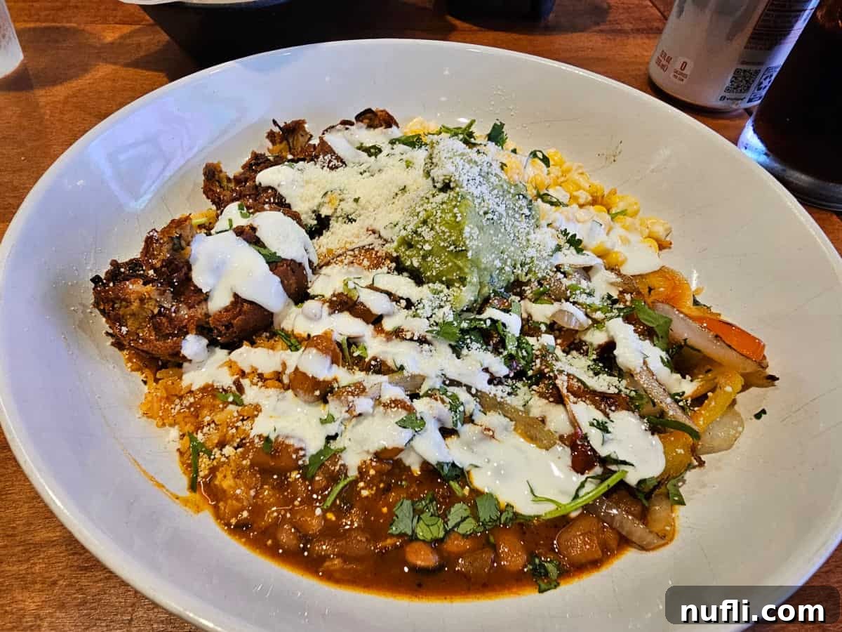 pinto bean falafel fajita bowl in a white bowl next to a drink