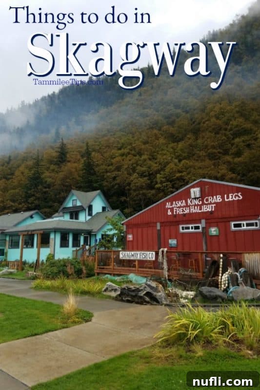 Things to do in Skagway over the red Skagway Fish Co building and trees up a hill