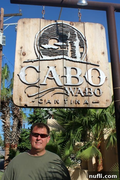 Cabo Wabo Cantina: Cabo's Legendary Party Spot 3 A traveler standing proudly by the iconic Cabo Wabo Cantina sign, ready to explore the legendary venue.