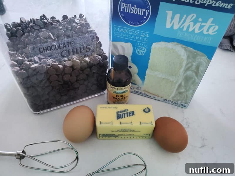Easy Cake Mix Chocolate Chip Cookies 3 Essential ingredients for chocolate chip cake mix cookies laid out: a box of cake mix, butter, eggs, vanilla extract, and chocolate chips.