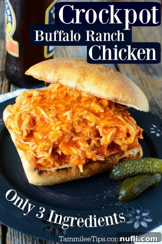 Crockpot Buffalo Ranch Chicken sandwich on a dark plate, garnished with dill pickles