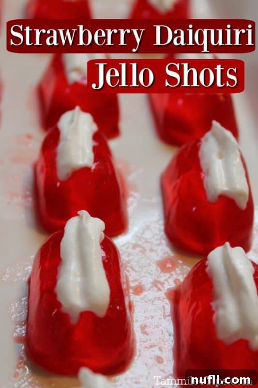 Luscious Strawberry Daiquiri Jello Shots 2 Vibrant Strawberry Daiquiri Jell-O Shots arranged neatly on a white platter, garnished with whipped cream and fresh strawberry slices.