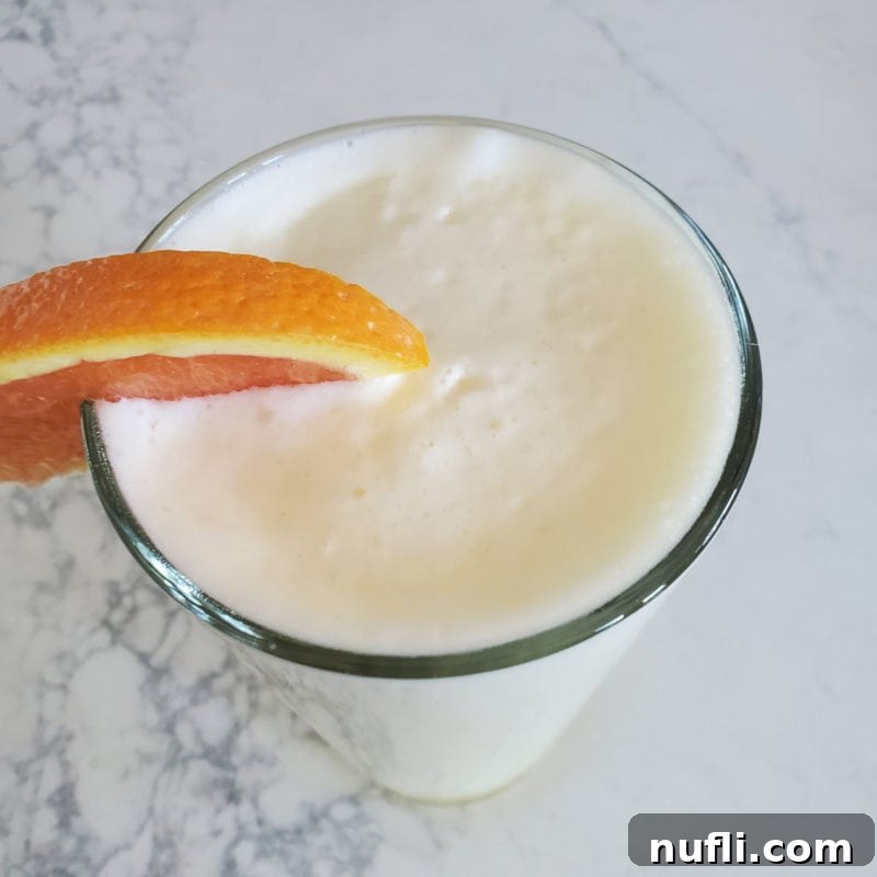 Copy Cat Orange Julius in a tall glass with an orange garnish