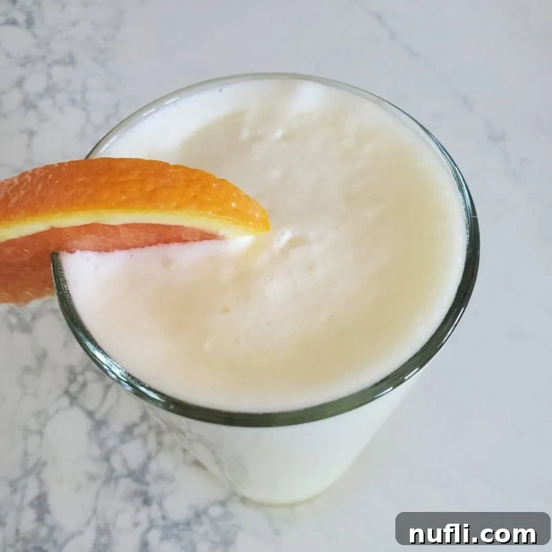 Copy Cat Orange Julius in a tall glass with an orange garnish