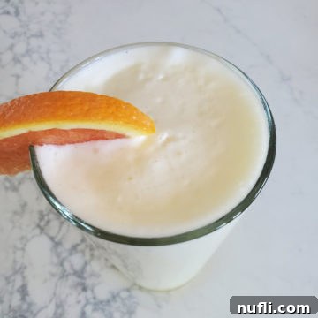 Copy Cat Orange Julius in a tall glass with an orange garnish