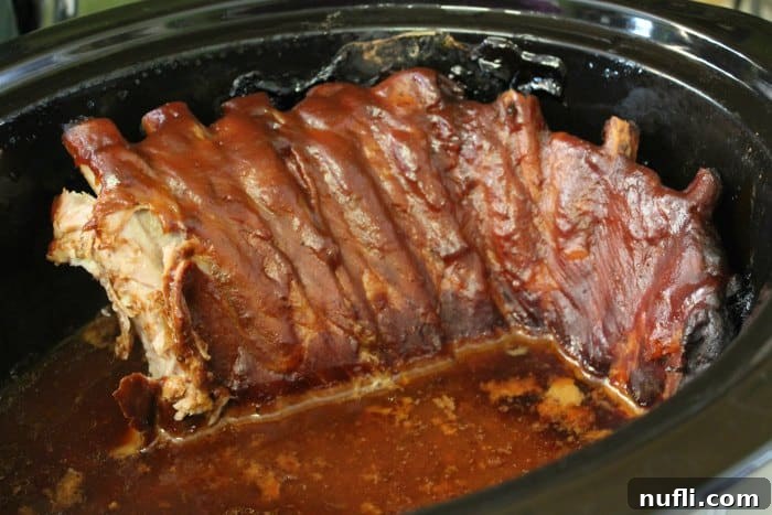 ribs covered in barbecue sauce in a crockpot