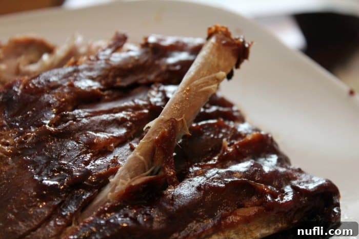 rib sticking out of crockpot ribs on a white platter