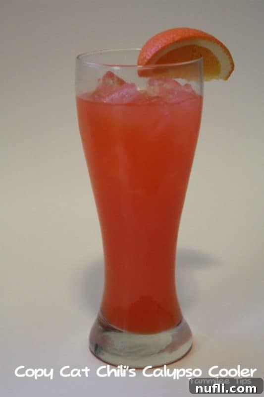 Red drink in a tall glass with tropical garnishes, labeled as Copy Cat Chili's Calypso Cooler