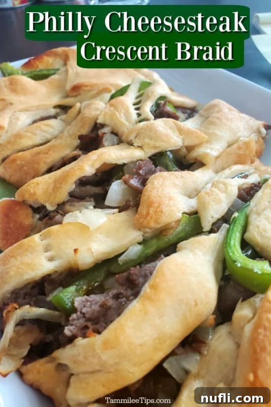 Golden-brown Philly Cheesesteak Crescent Braid served on a white plate, showcasing its flaky crust and savory filling.