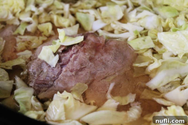 corned beef in the slow cooker with cabbage floating 