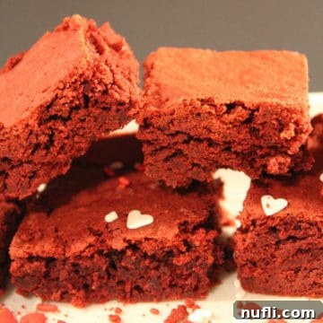 Red Velvet Brownies from Cake Mix stacked on a white plate with heart sprinkles