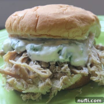 Slow Cooked Cuban Pork Sandwiches with Zesty Cilantro Mayo 3 Cuban pulled pork sandwich on a green plate