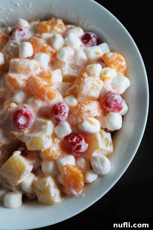 Marshmallow Fruit Salad in a white serving bowl with a black background