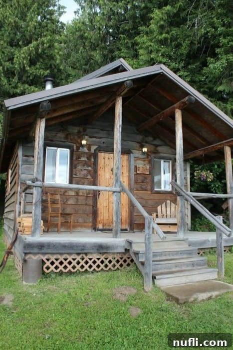 Charming rustic cabin at Bull Hill Guest Ranch, nestled amidst lush greenery with a cozy front porch, inviting guests to relax and unwind.