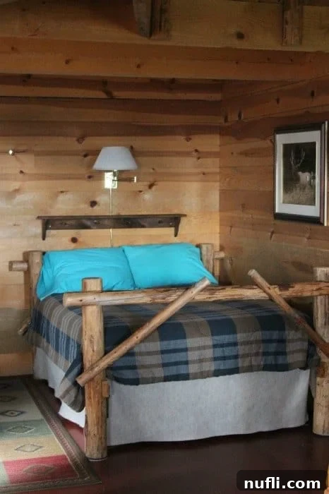 Rustic wood-framed bed with plush turquoise pillows inside a cozy cabin at Bull Hill Guest Ranch, showcasing comfortable and charming accommodations.