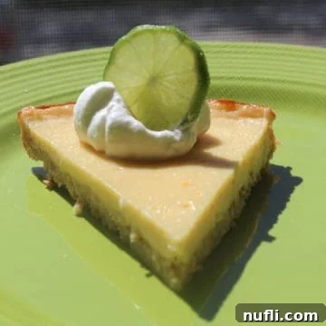 Margarita pie with a lime wheel on a green plate, ready to be enjoyed.