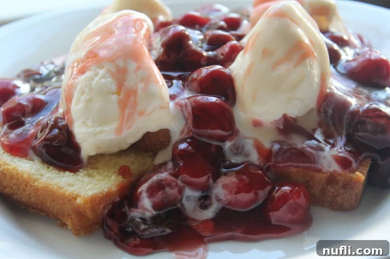 Cherries jubilee on pound cake with 2 scoops of ice cream