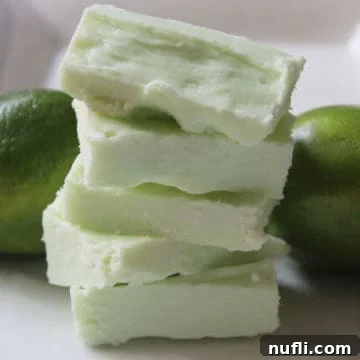 2 Ingredient Key Lime Fudge stacked on a white plate next to limes