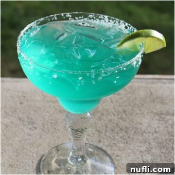 Blue agave margarita in a margarita glass with lime wedge