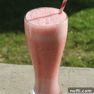 Recreating the Iconic Orange and Strawberry Julius 3 Orange Julius Strawberry Julius in a tall glass with a striped straw