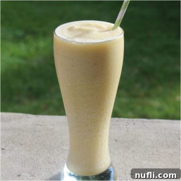 Banana Julius in a tall glass with paper straw, ready to be enjoyed.
