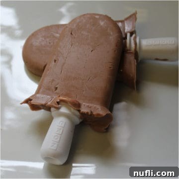 Two creamy Nutella Popsicles on a white platter, ready to be enjoyed.