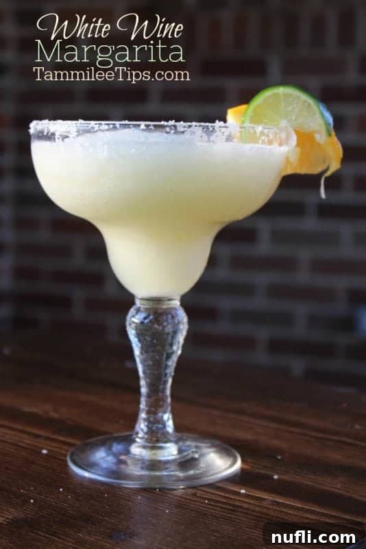 Crisp White Wine Margarita 4 White wine margarita in a classic margarita glass garnished with lime and orange wheel