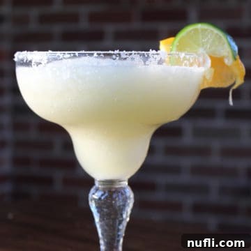 Crisp White Wine Margarita 5 White Wine Margarita in a margarita glass with salt rim and lime wheel