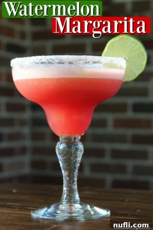 Refreshingly Simple Watermelon Margarita Video 2 Watermelon margarita over a margarita glass wtih drink garnished with a lime wheel