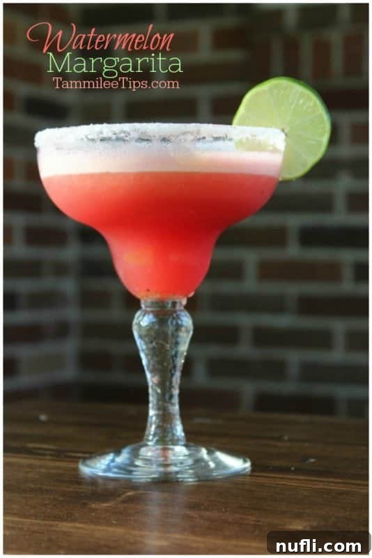 Refreshingly Simple Watermelon Margarita Video 4 Watermelon margarita over a margarita glass garnished with a lime wheel