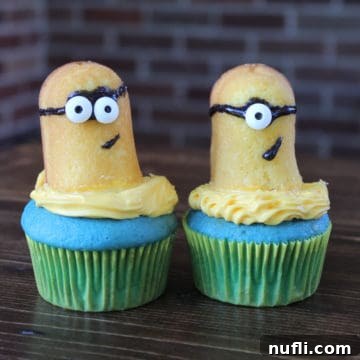 Minion Cupcakes on a wood board, a detailed shot showing the goggle and overall decorations on these fun Despicable Me treats.