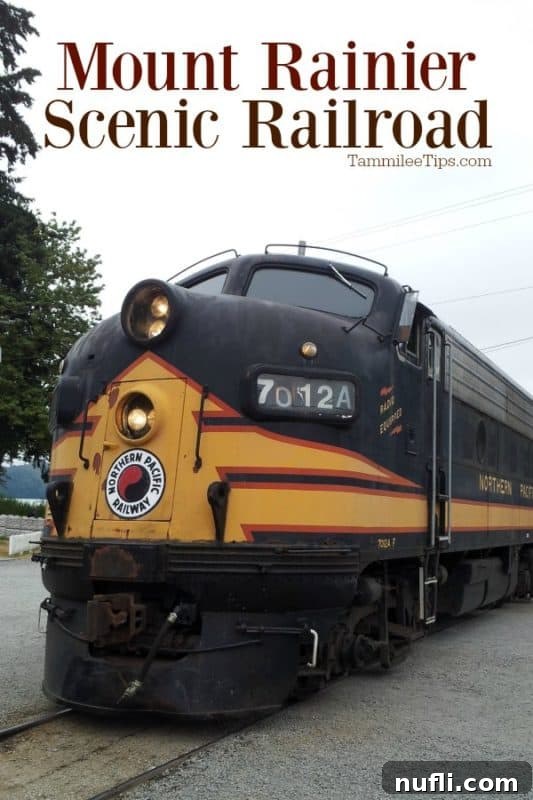 A powerful F9 Diesel engine from the Mount Rainier Scenic Railroad leading a train through the lush landscape.