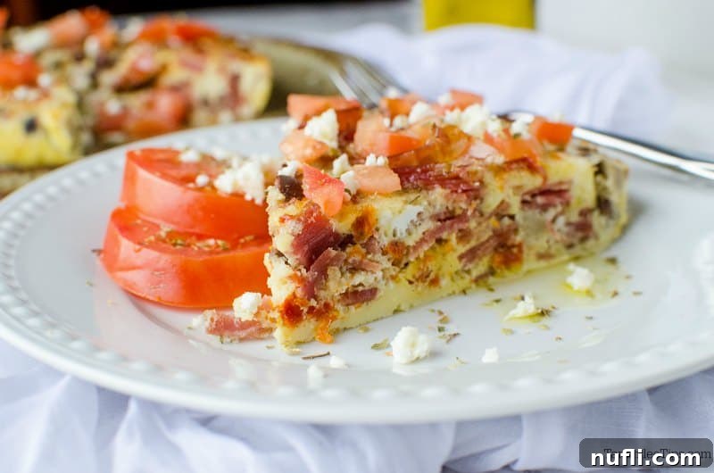 plate with a slice of Greek frittata and tomatoes, next to serving dish.