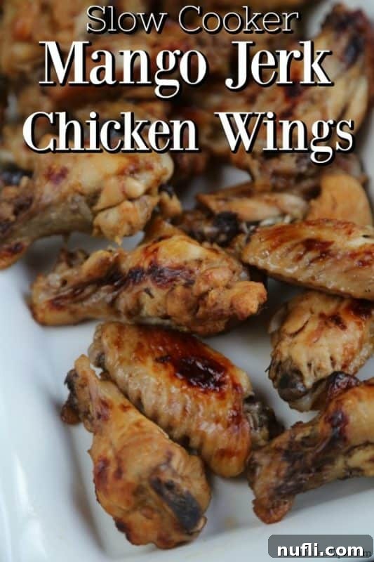 Slow Cooker Mango Jerk Chicken Wings on a white platter, garnished with fresh cilantro.