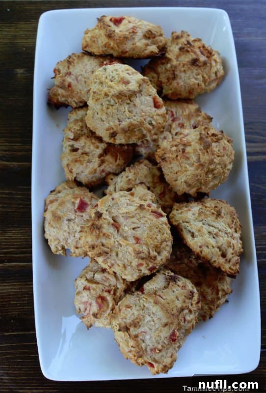 Southwest Biscuits arranged neatly on a white platter, invitingly golden and speckled with cheese and chili.
