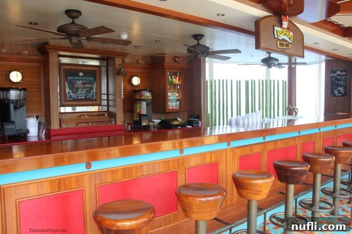 Wood topped stools at a bar with a RedFrog Rum Bar sign and outdoor fans