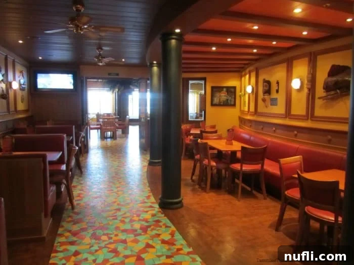 Comfortable tables and chairs arranged in the Red Frog Pub, featuring tropical decor and a colorful tile floor, inviting guests to relax.