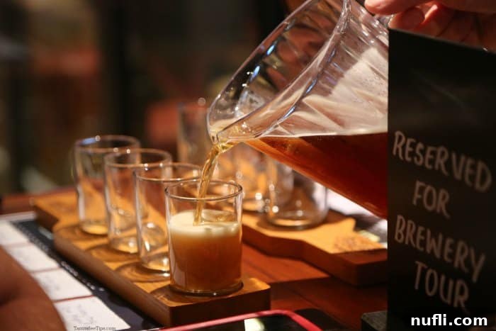 Beer pouring into a flight of glasses on a wood board