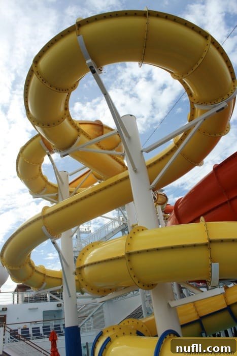 Carnival Waterworks: Your Ultimate Summer Splash 2 Vibrant yellow waterslide spiraling down on a Carnival cruise ship deck, inviting guests to a thrilling ride.