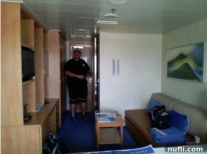 John standing near the entrance of the Carnival Breeze stateroom, showcasing the room's spaciousness