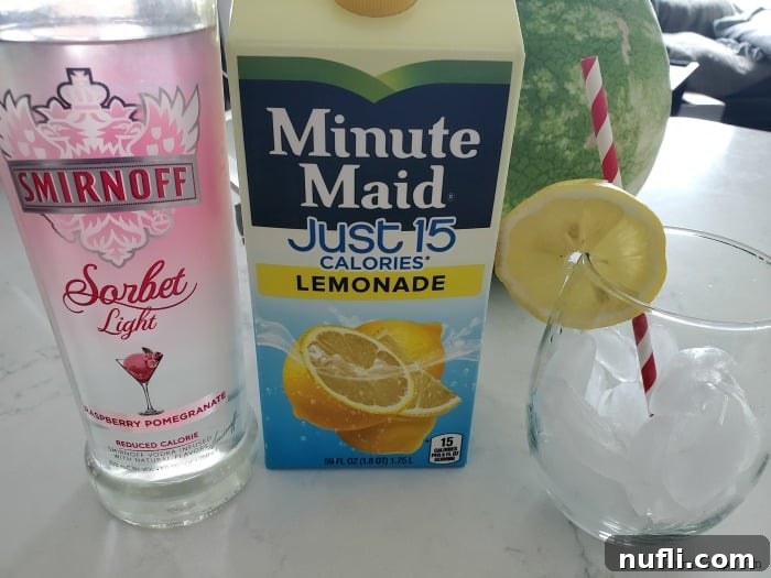 Ingredients for Smirnoff Sorbet Light Raspberry Pomegranate Lemonade Cocktail: a bottle of Smirnoff Sorbet Light vodka, Minute Maid Just 15 Calories Lemonade, and a prepared glass with lemon wheel and straw